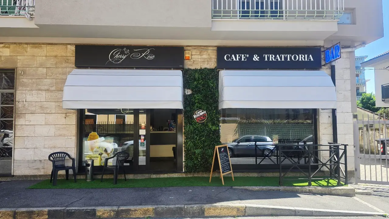 La facciata del locale in Via Cefalonia, con l’insegna, le tende bianche e i tavolini fuori